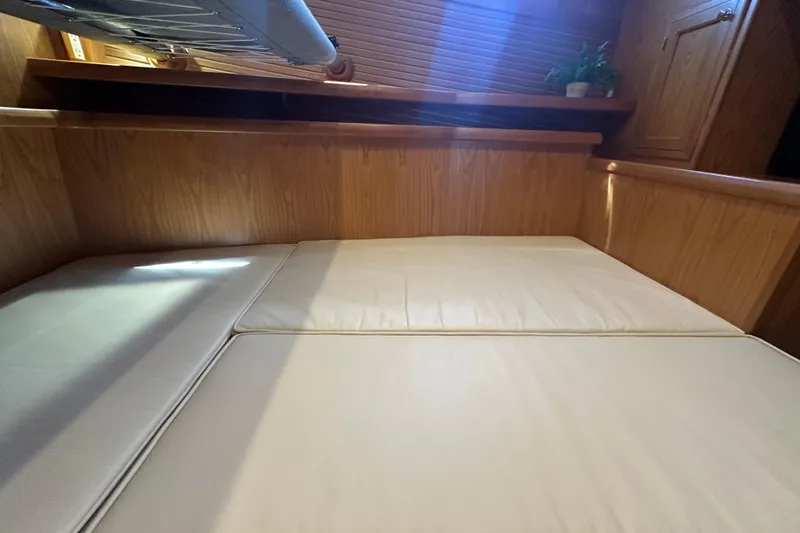 Slide: The Image of 2021 Kadey-Krogen 44AE interior cabin with wooden finish and cushioned seating. - 27