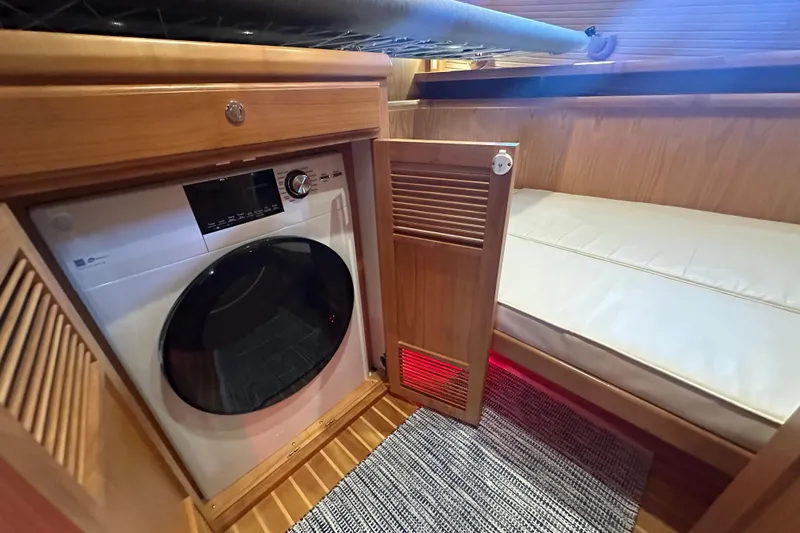 Slide: The Image of 2021 Kadey-Krogen 44AE interior with washer and cozy wooden cabin bed. - 29