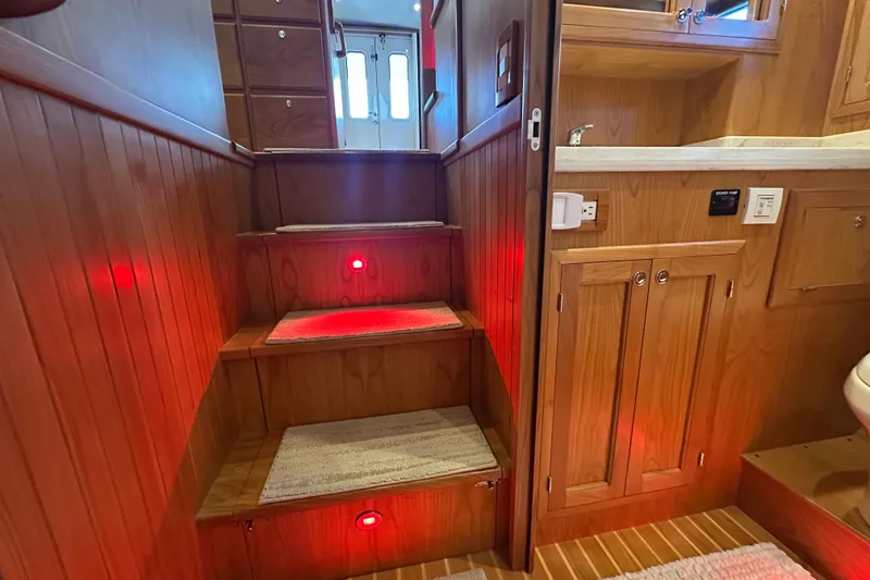 Slide: The Image of Interior of 2021 Kadey-Krogen 44AE yacht with wooden stairs and red lighting. - 32