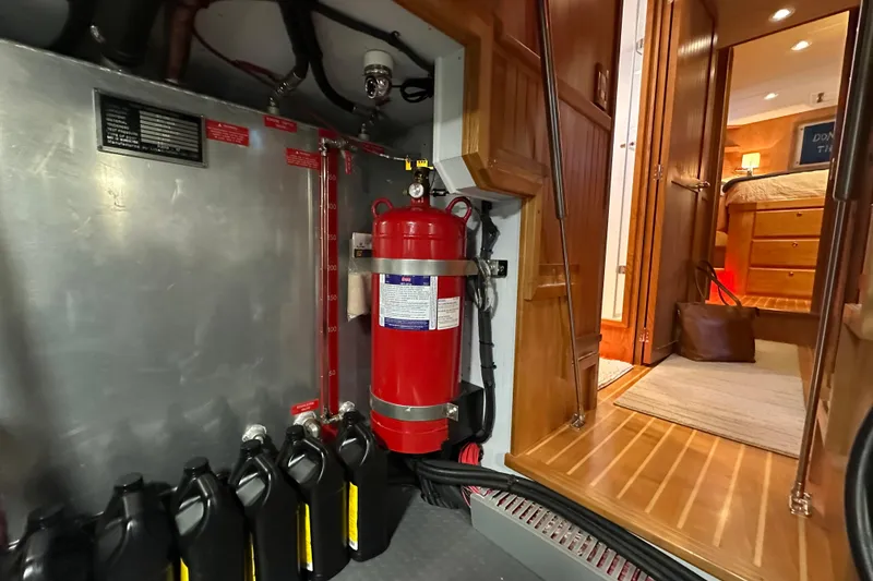 Slide: The Image of Engine room of 2021 Kadey-Krogen 44AE yacht with fire extinguisher and oil containers. - 40