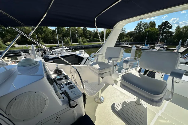 Slide: The Image of Flybridge of 2021 Kadey-Krogen 44AE yacht with helm chairs and marina view. - 45