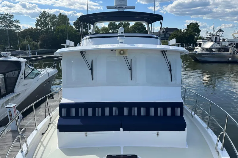 Slide: The Image of Kadey-Krogen 44AE 2021 yacht docked, featuring a spacious deck and striped seating. - 53