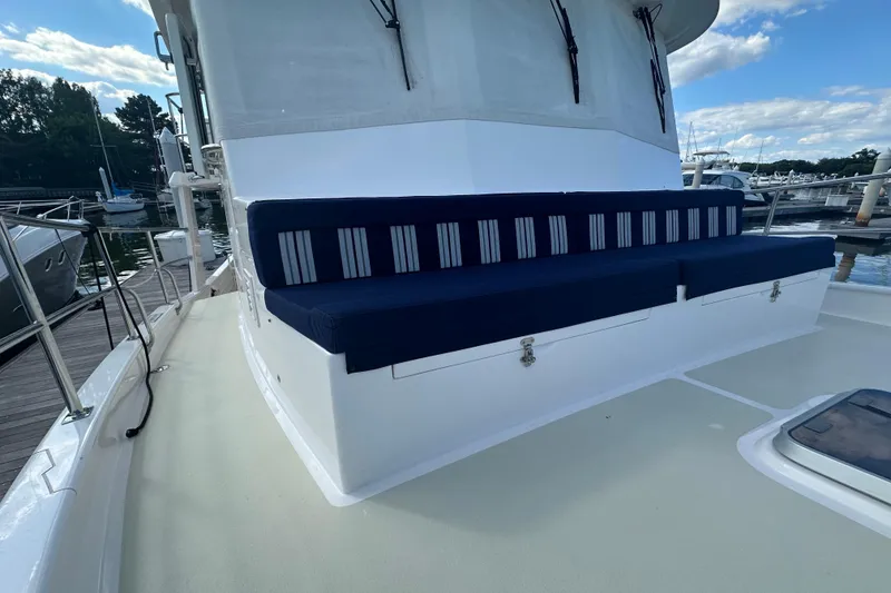 Slide: The Image of Kadey-Krogen 44AE 2021 yacht with blue-striped seating on deck, docked at marina. - 54
