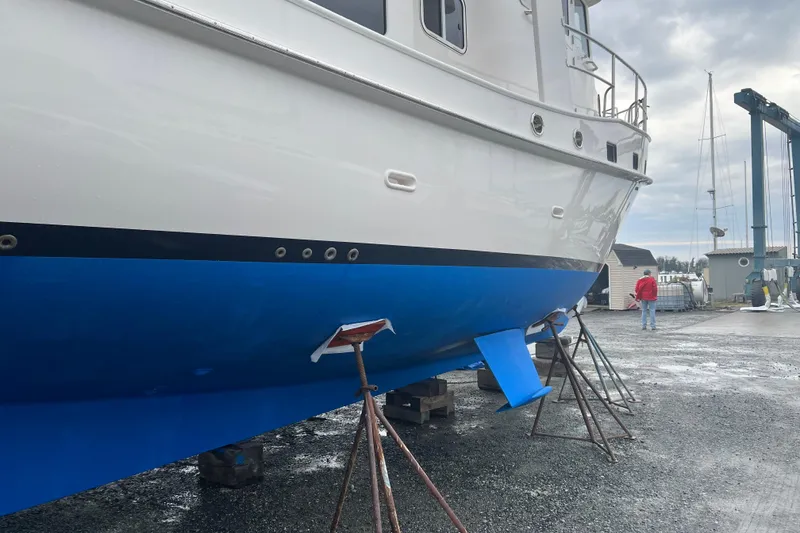 Slide: The Image of 2021 Kadey-Krogen 44AE yacht on dry dock with blue hull and supports. - 62