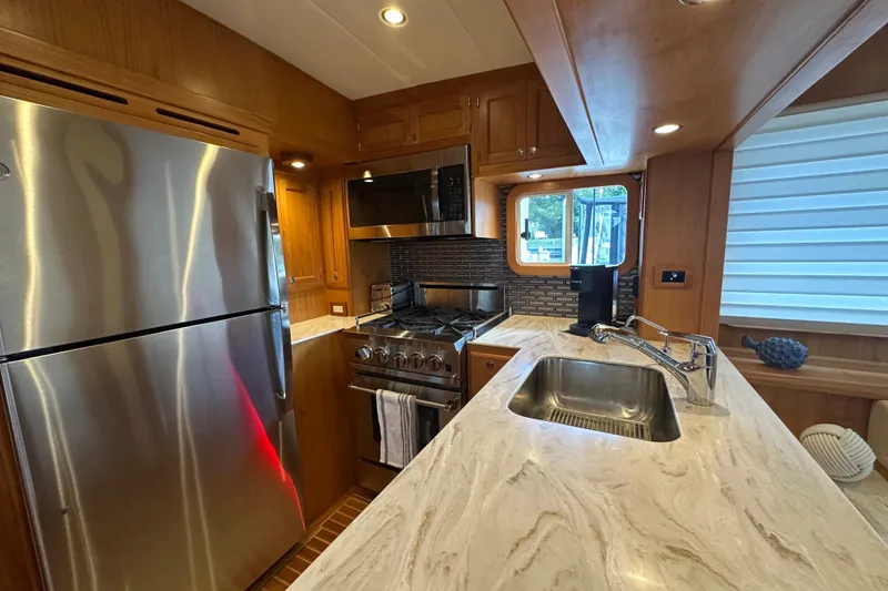 Slide: The Image of Modern kitchen in 2021 Kadey-Krogen 44AE yacht with stainless steel appliances and marble countertops. - 8