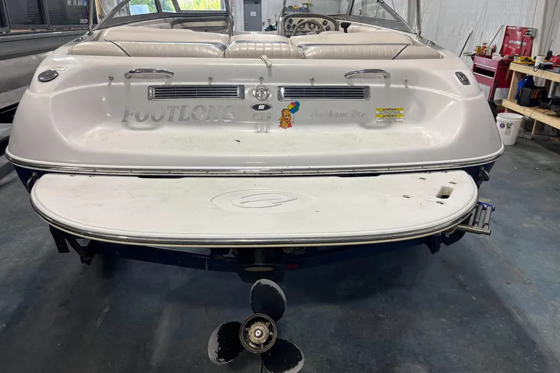 Slide: The Image of 2013 Crownline 185 SS boat in a garage, rear view with swim platform and propeller. - 2