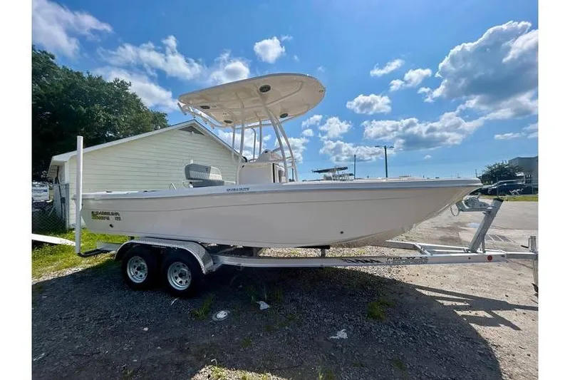 Slide: The Image of 2026 Carolina Skiff 21 Ultra Elite boat on trailer under blue sky. - 8
