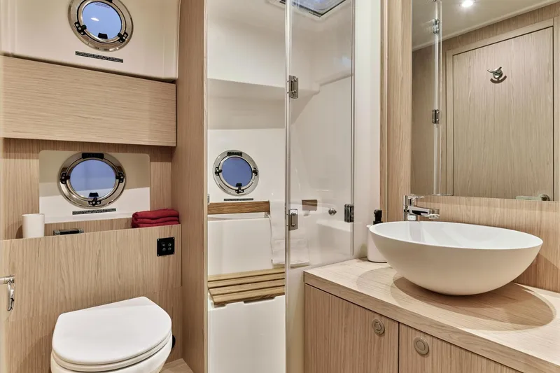 Slide: The Image of Luxurious bathroom in 2026 Beneteau Swift Trawler 48 with modern fixtures and porthole windows. - 10