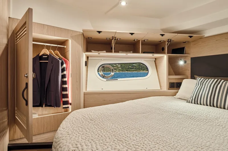 Slide: The Image of Luxurious cabin interior of 2026 Beneteau Swift Trawler 48 with wardrobe and porthole view. - 13