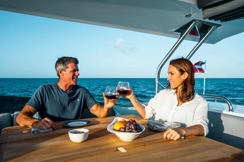 Slide: The Image of Couple enjoying wine on a 2026 Beneteau Swift Trawler 48, ocean backdrop. - 15