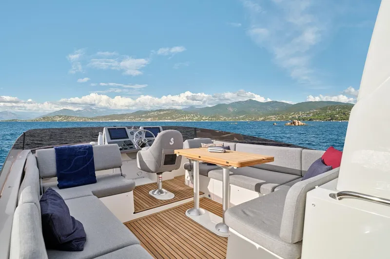 Slide: The Image of 2026 Beneteau Swift Trawler 48 deck with seating, table, and ocean view. - 16