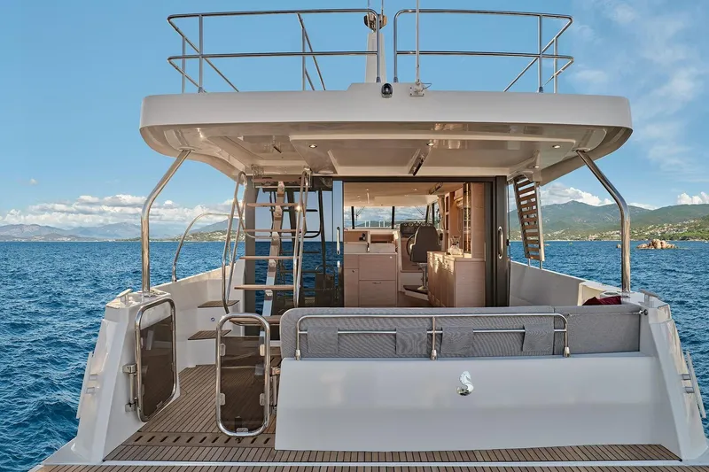 Slide: The Image of 2026 Beneteau Swift Trawler 48, rear view on open sea, showcasing deck and interior. - 21