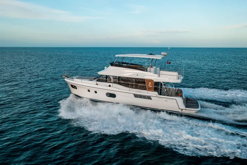 Slide: The Image of 2026 Beneteau Swift Trawler 48 cruising on open sea under clear sky. - 25