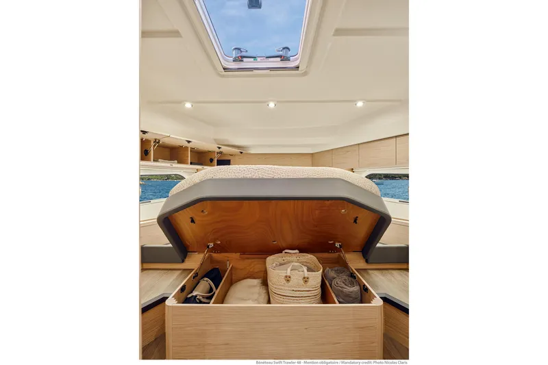 Slide: The Image of Interior of 2026 Beneteau Swift Trawler 48 with under-bed storage and skylight view. - 9
