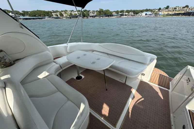 Slide: The Image of 2000 Sea Ray 380 Sundancer boat interior with white seating and table on the water. - 20