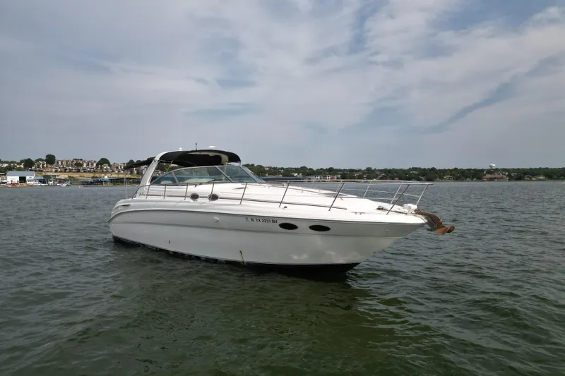 Slide: The Image of 2000 Sea Ray 380 Sundancer yacht on calm water under a cloudy sky. - 4