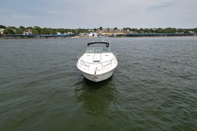 Slide: The Image of 2000 Sea Ray 380 Sundancer yacht on calm water near a coastal town. - 5