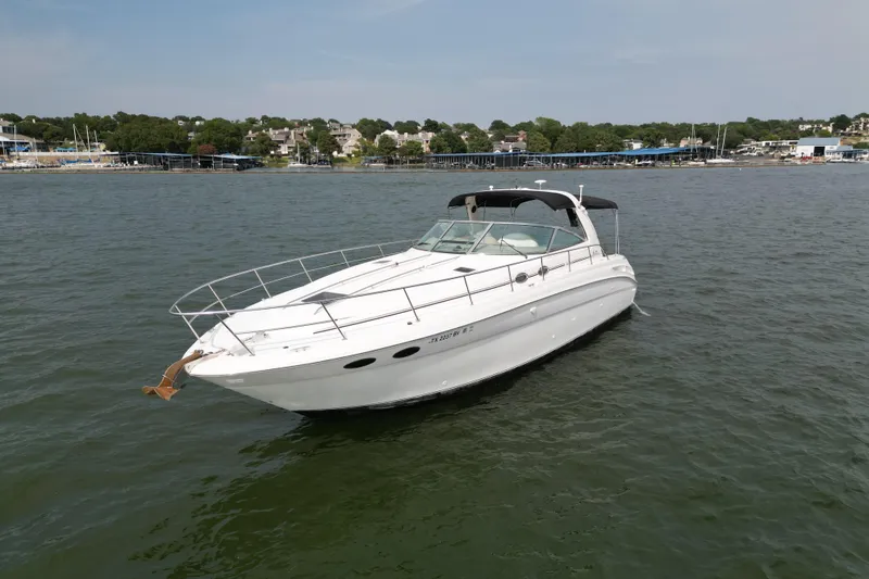 Slide: The Image of 2000 Sea Ray 380 Sundancer yacht on calm water near a marina. - 6