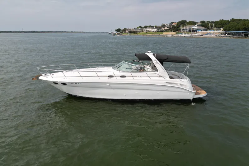 Slide: The Image of 2000 Sea Ray 380 Sundancer yacht on calm water, with scenic shoreline in background. - 7