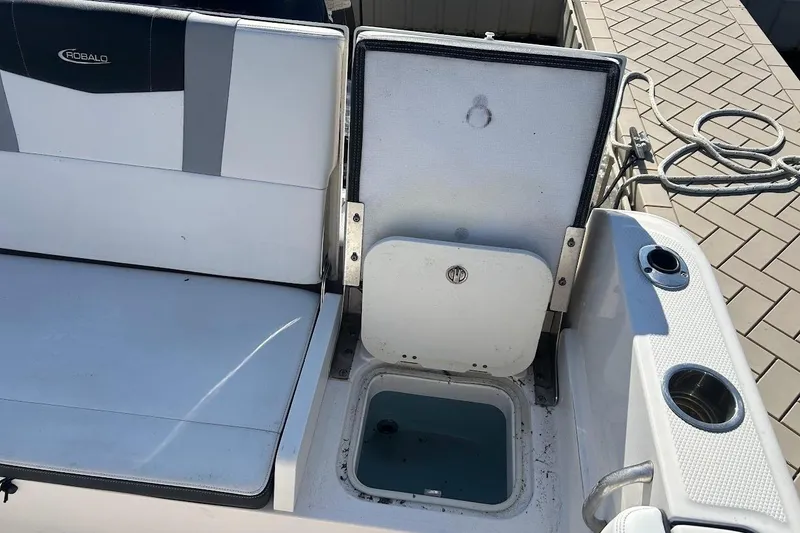 Slide: The Image of 2020 Robalo R230 Center Console boat with open storage compartments at marina. - 13