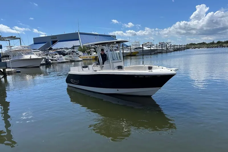 Slide: The Image of 2020 Robalo R230 Center Console boat docked in a marina under a clear blue sky. - 3