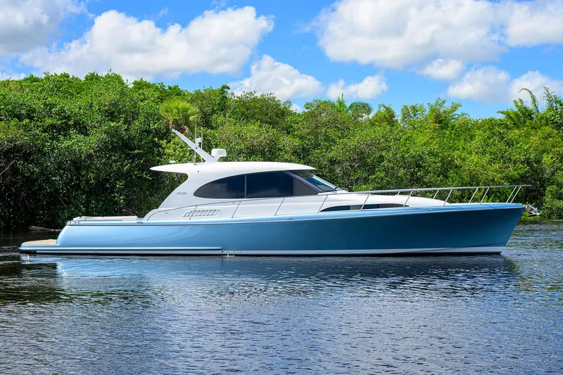 The Image of 2024 Palm Beach Motor Yachts GT50 on serene water, lush greenery background. - 0