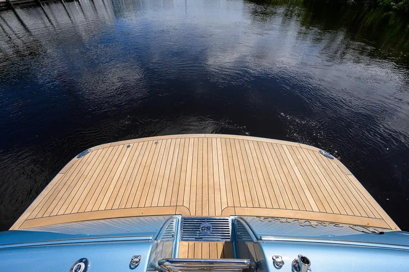 Slide: The Image of 2024 Palm Beach Motor Yachts GT50, teak deck, overlooking calm water. - 12