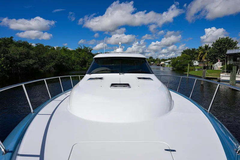 Slide: The Image of 2024 Palm Beach Motor Yachts GT50 cruising on a scenic waterway under a blue sky. - 31
