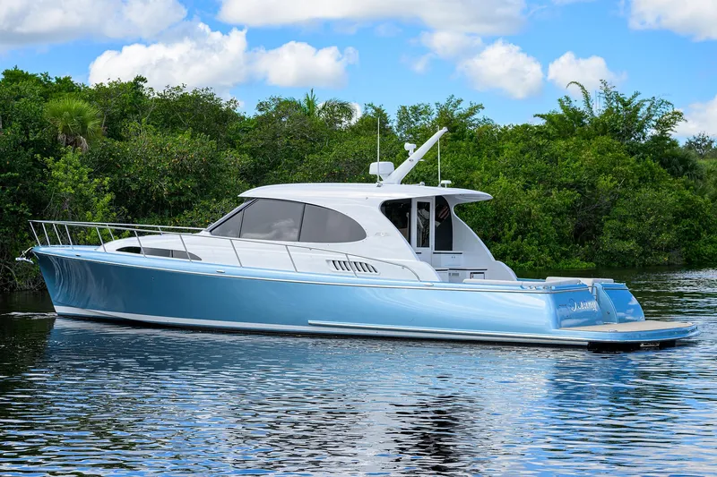 Slide: The Image of 2024 Palm Beach Motor Yachts GT50 cruising on a serene waterway, surrounded by lush greenery. - 5