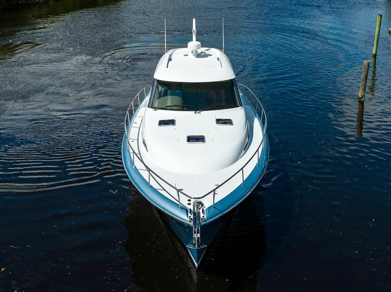 Slide: The Image of 2024 Palm Beach Motor Yachts GT50 cruising on calm water, aerial front view. - 8