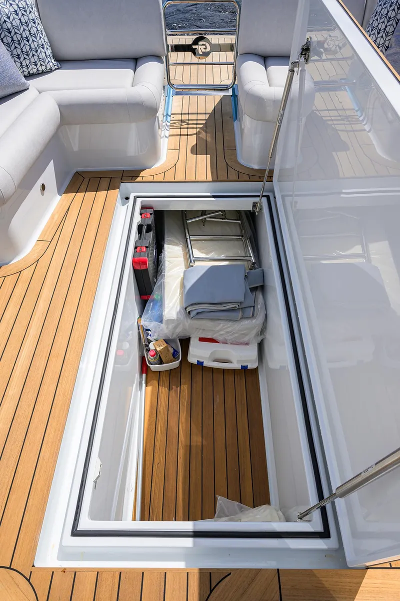 Slide: The Image of 2024 Palm Beach Motor Yachts GT50 storage compartment with teak flooring and seating area. - 25