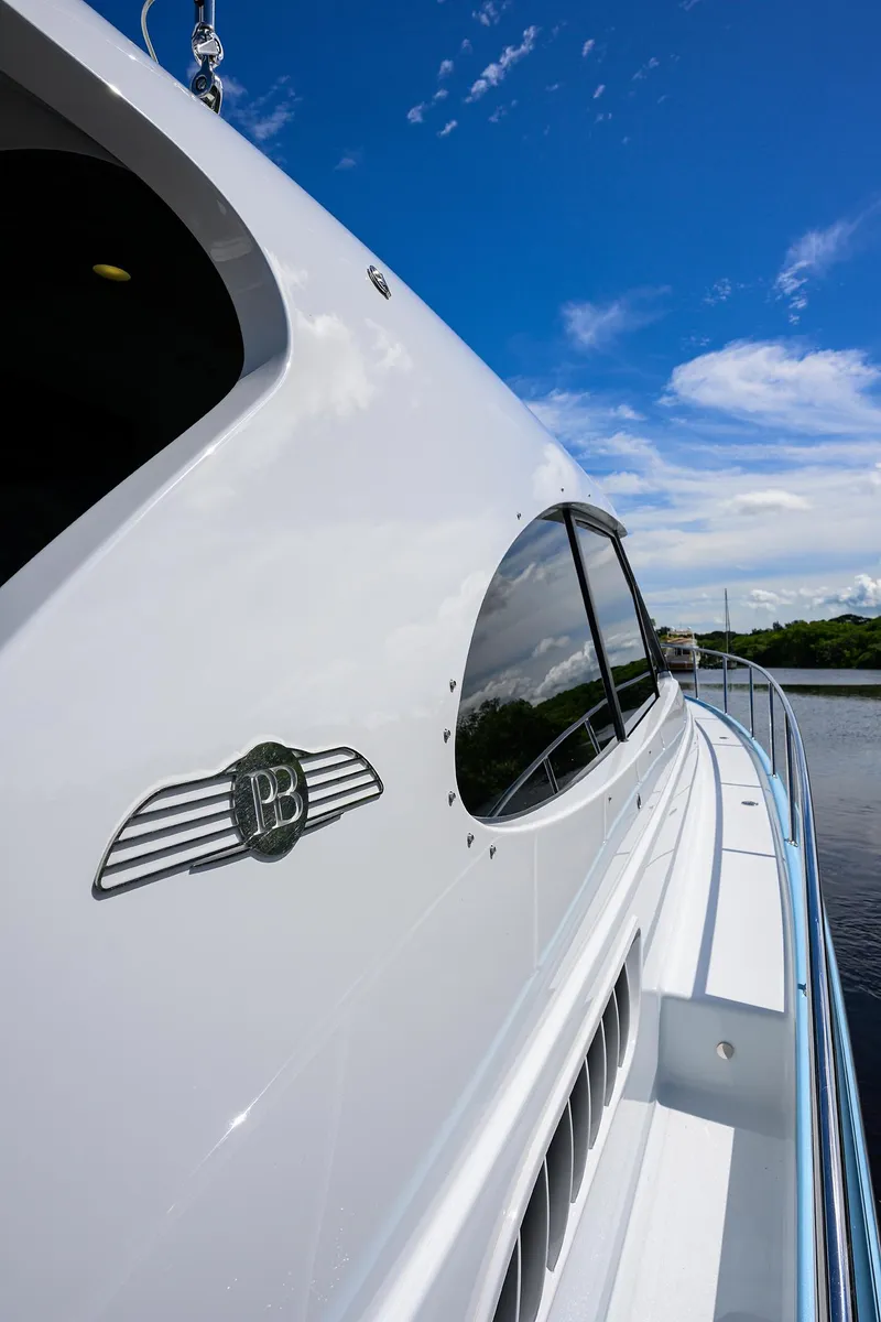 Slide: The Image of 2024 Palm Beach Motor Yachts GT50, sleek design, cruising under a clear blue sky. - 27