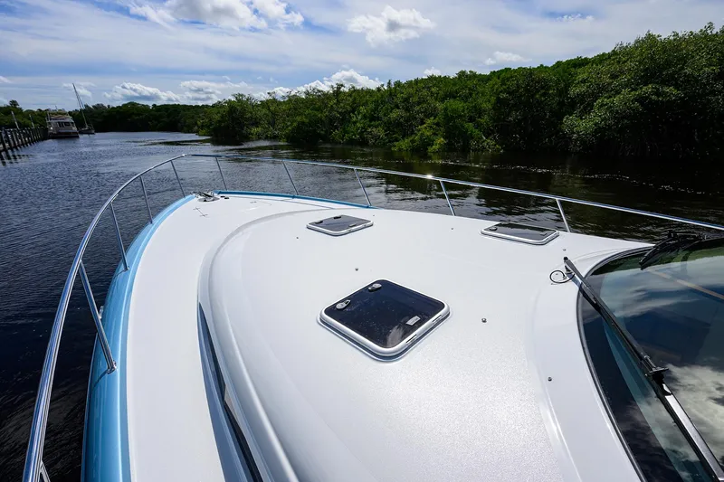 Slide: The Image of 2024 Palm Beach Motor Yachts GT50 cruising on a serene river with lush greenery. - 28