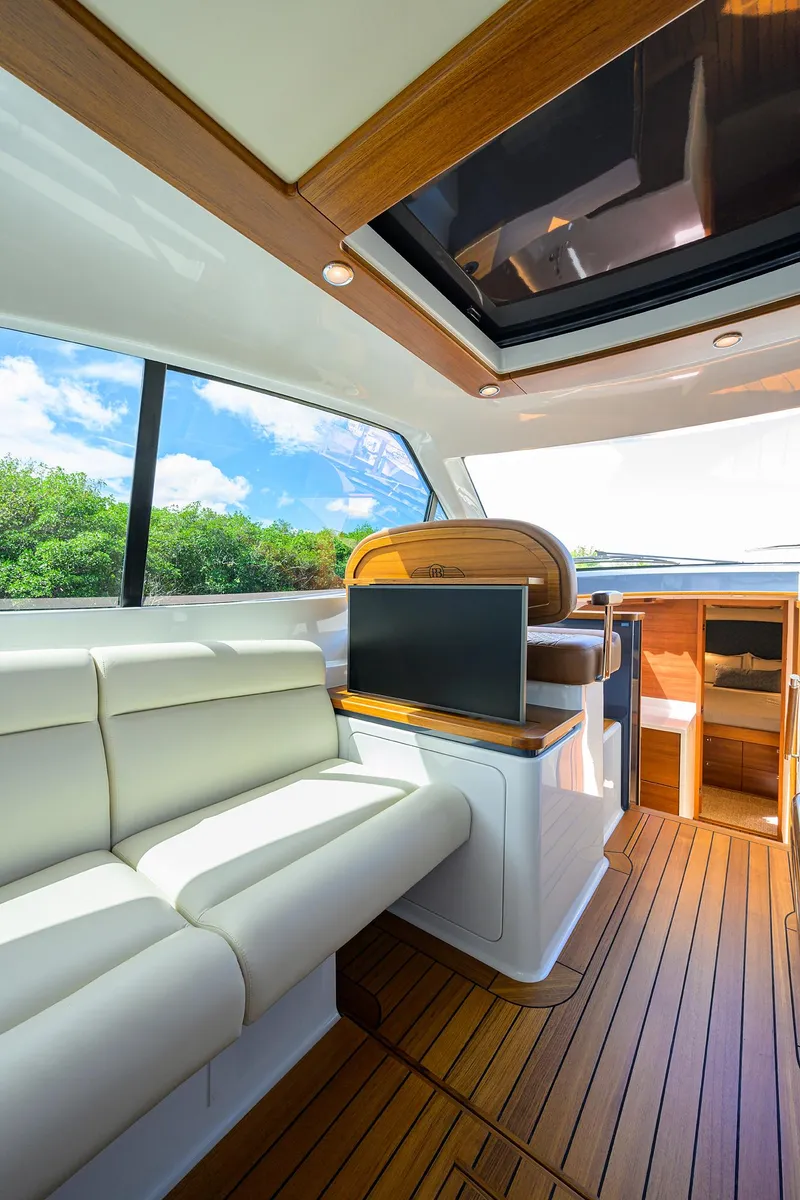 Slide: The Image of 2024 Palm Beach Motor Yachts GT50 interior with luxurious seating and wood finishes. - 39