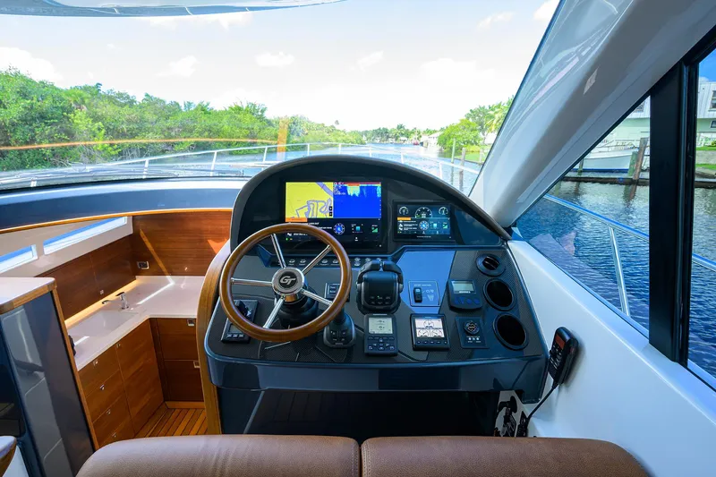 Slide: The Image of 2024 Palm Beach Motor Yachts GT50 helm with modern navigation system and wooden steering wheel. - 46