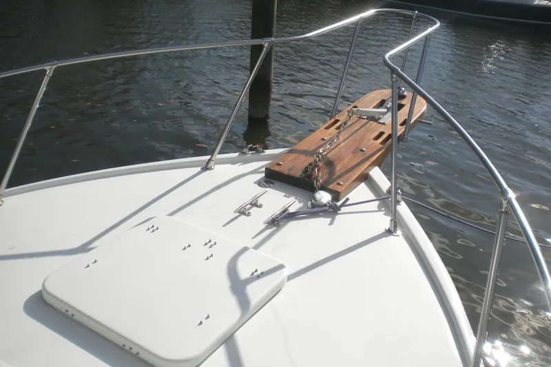 Slide: The Image of 1979 Bertram Flybridge Cruiser bow with anchor, railing, and water view. - 1