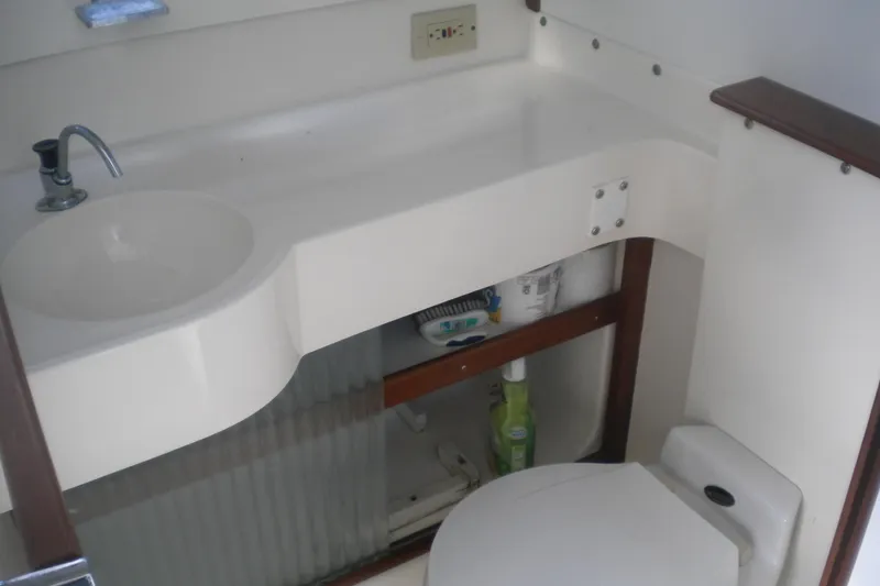 Slide: The Image of 1979 Bertram Flybridge Cruiser bathroom with sink, faucet, and toilet. - 19