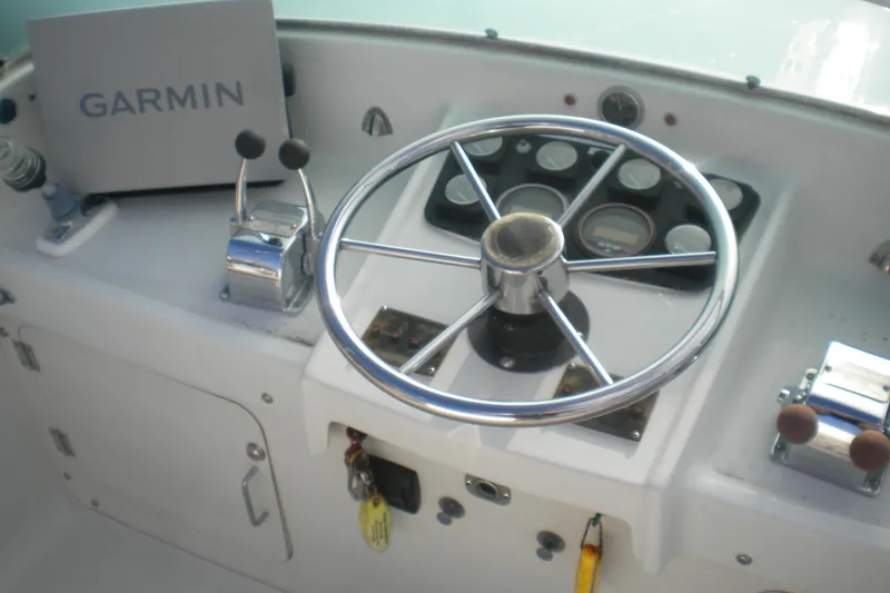 Slide: The Image of 1979 Bertram Flybridge Cruiser helm with Garmin navigation and classic steering wheel. - 2