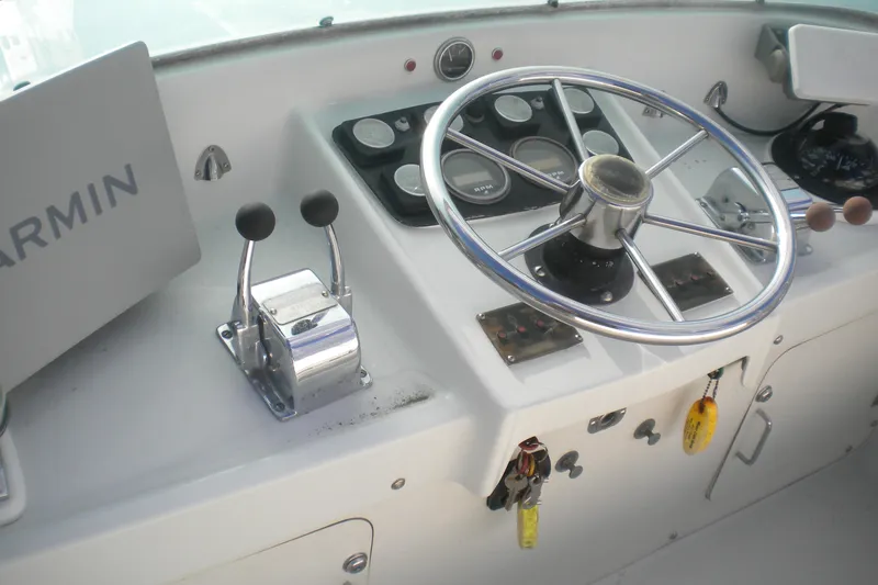 Slide: The Image of 1979 Bertram Flybridge Cruiser helm with steering wheel, controls, and Garmin navigation system. - 3