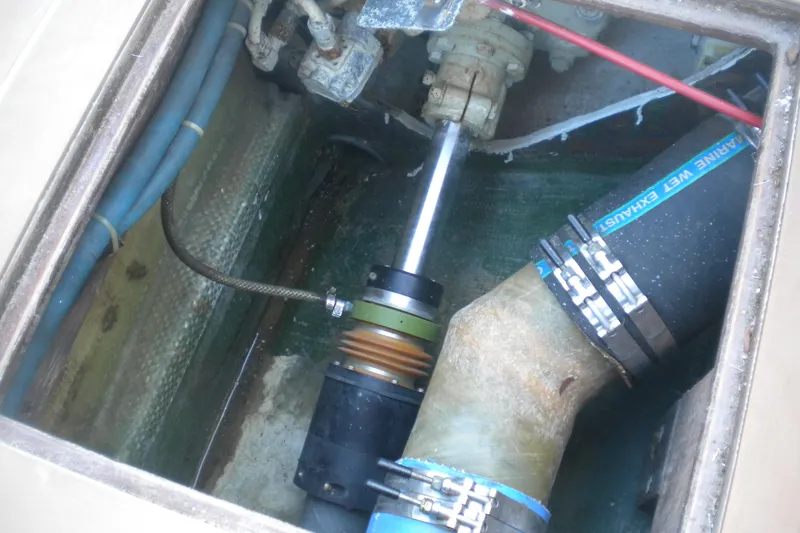 Slide: The Image of 1979 Bertram Flybridge Cruiser engine compartment with marine exhaust system components. - 18