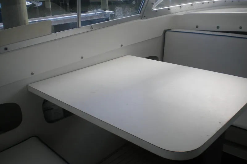 Slide: The Image of 1979 Bertram Flybridge Cruiser interior with white table and seating. - 8