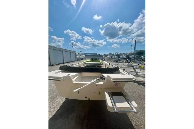 Slide: The Image of 2026 Carolina Skiff 16 JVX CC boat, rear view under sunny sky at marina. - 3