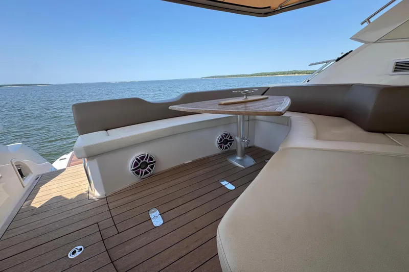 Slide: The Image of 2013 Sessa Marine C44 Cruiser deck with seating and table, overlooking serene waters. - 17