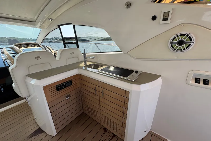 Slide: The Image of 2013 Sessa Marine C44 Cruiser interior with helm, sink, and wooden cabinetry. - 18