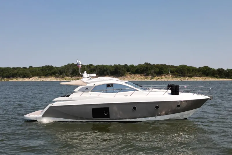 Slide: The Image of 2013 Sessa Marine C44 Cruiser yacht on calm water, scenic shoreline background. - 2