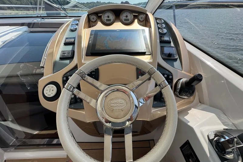 Slide: The Image of 2013 Sessa Marine C44 Cruiser helm with steering wheel and navigation controls. - 26
