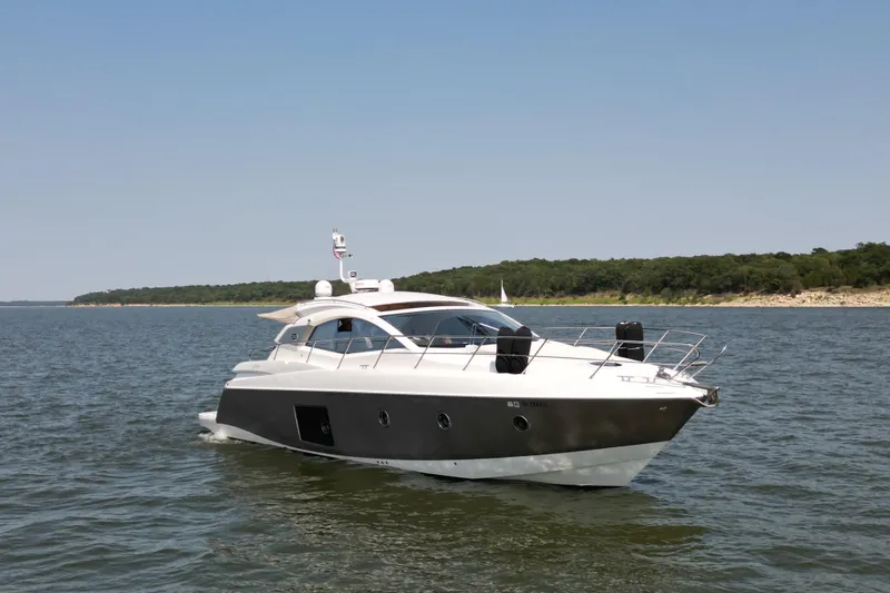 Slide: The Image of 2013 Sessa Marine C44 Cruiser on serene water with forested shoreline. - 3