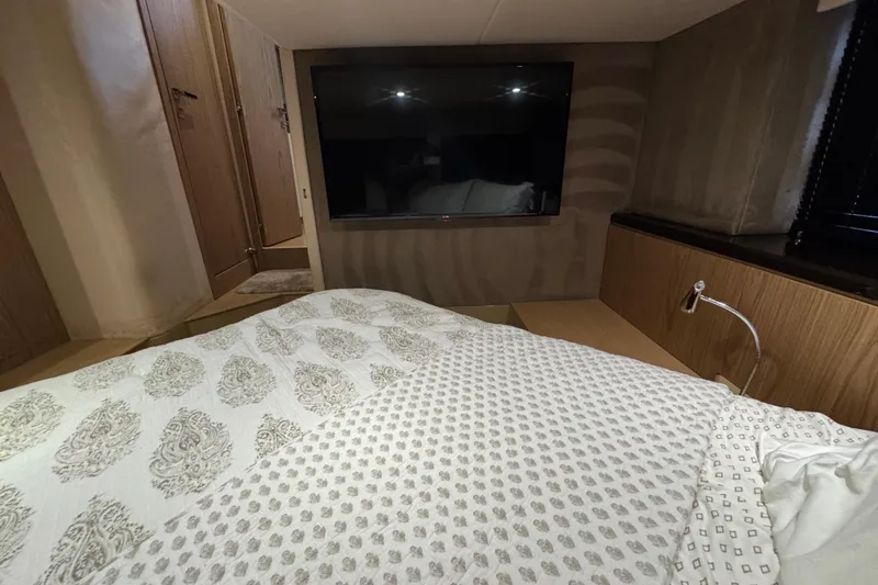 Slide: The Image of Bedroom interior of 2013 Sessa Marine C44 Cruiser with TV and patterned bedding. - 35