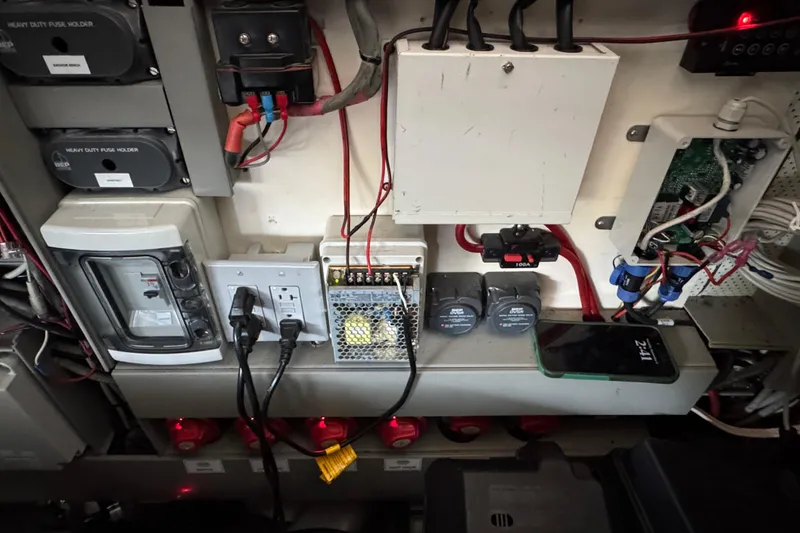 Slide: The Image of Electrical panel of a 2013 Sessa Marine C44 Cruiser with various components and wiring. - 53