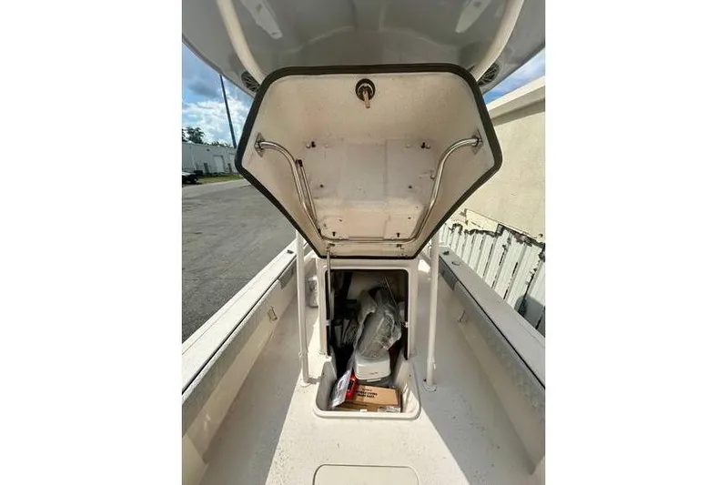 Slide: The Image of 2026 Carolina Skiff 24 Ultra Elite boat storage compartment open, revealing interior contents. - 3